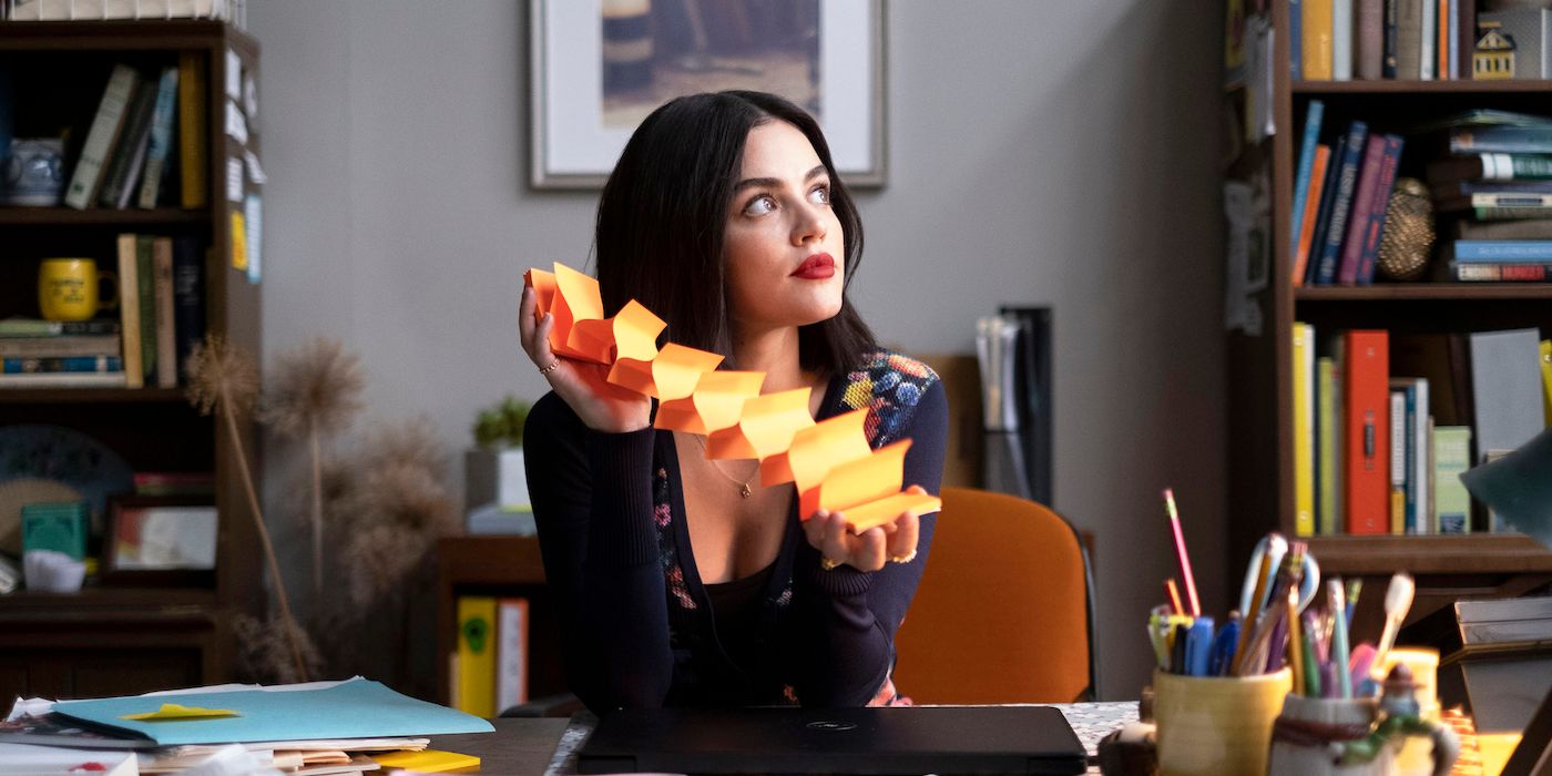Lucy pulls post-it notes apart while sitting at her desk in The Hating Game.