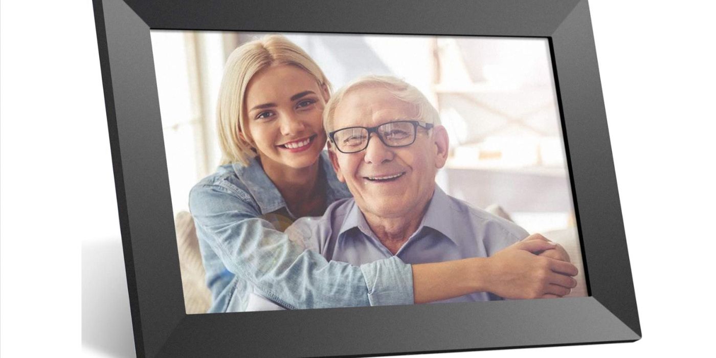 A digital photo frame shows a picture of two smiling people