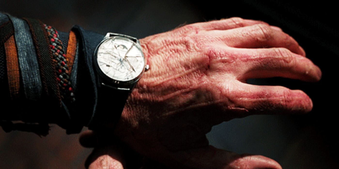 Benedict Cumberbatch como Doutor Estranho com a mão machucada e relógio quebrado no filme Doutor Estranho.