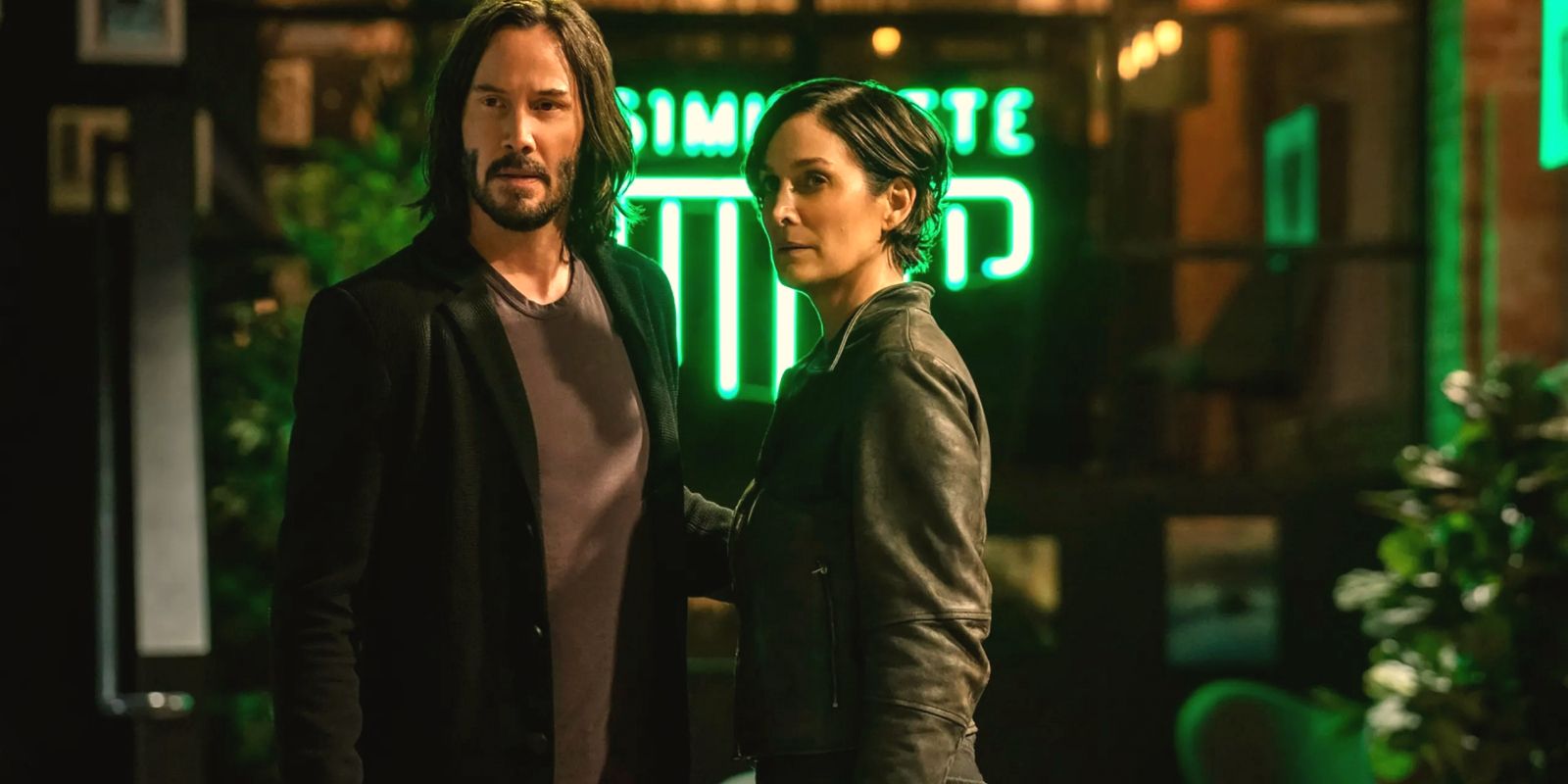 Keanu Reeves and Carrie-Anne Moss as Neo and Trinity looking concerned in The Matrix Resurrections.