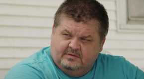 Chris Combs in 1000-lb Sisters star looking sideways in blue t-shirt