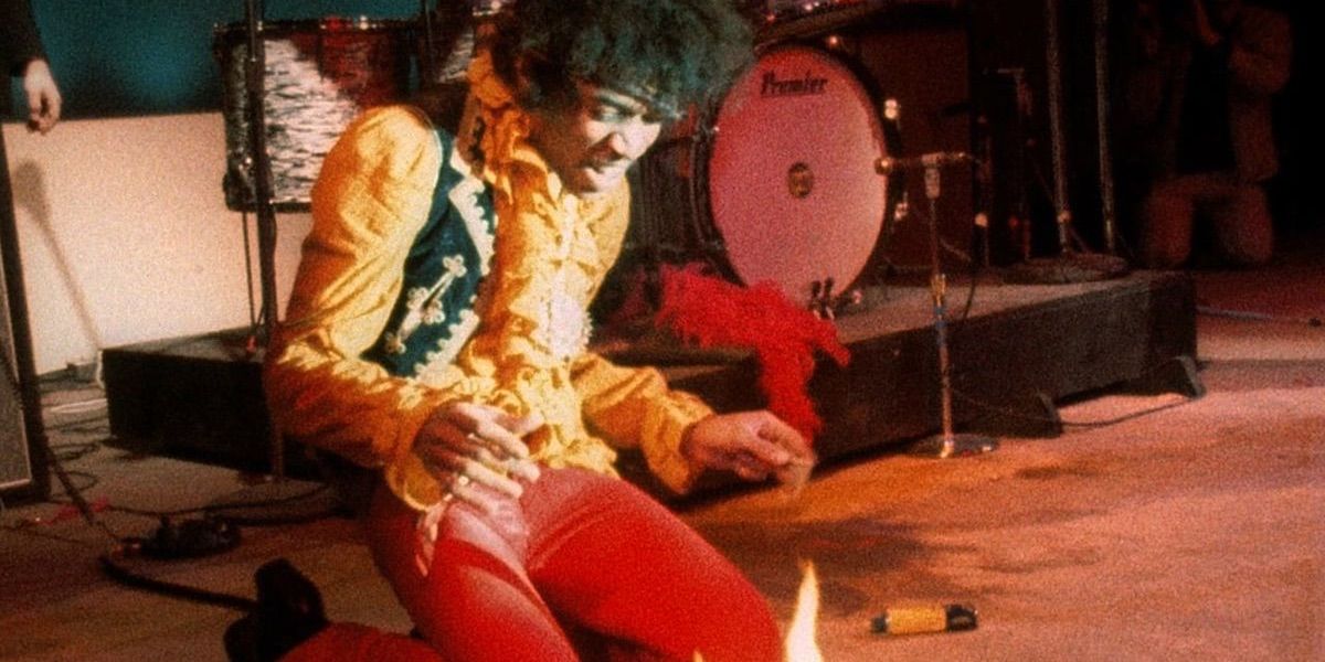 Jimi Hendrix kneels over his burning guitar from Monterey Pop