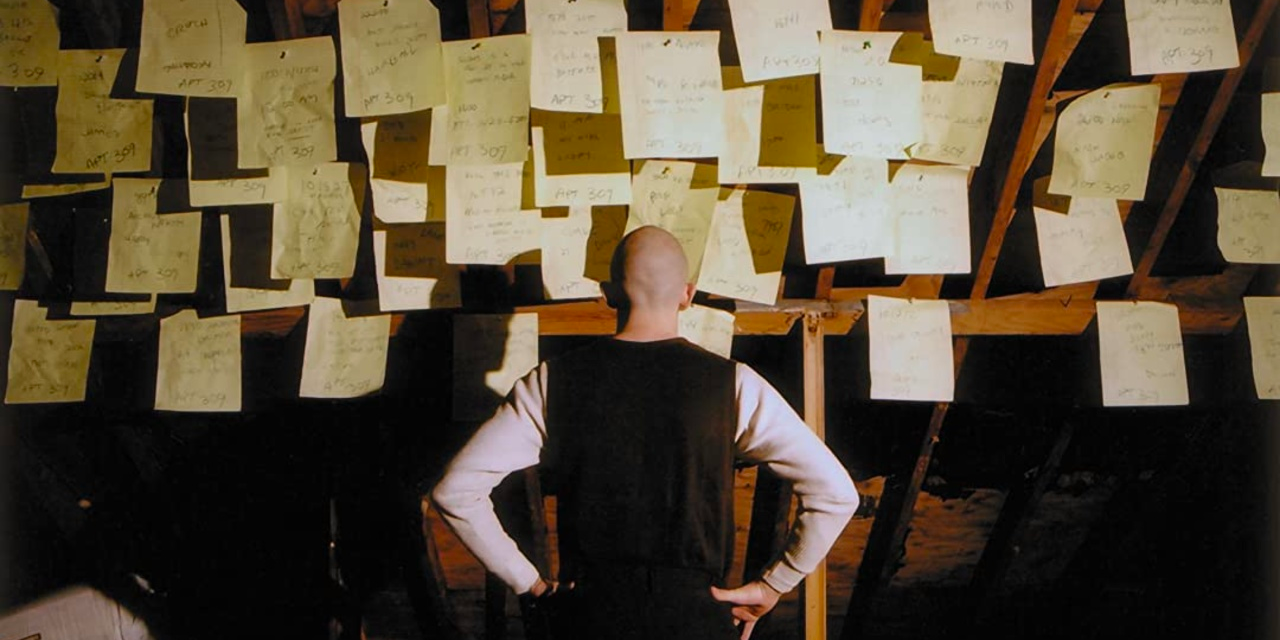 A man looks at a wall of papers in Firefly
