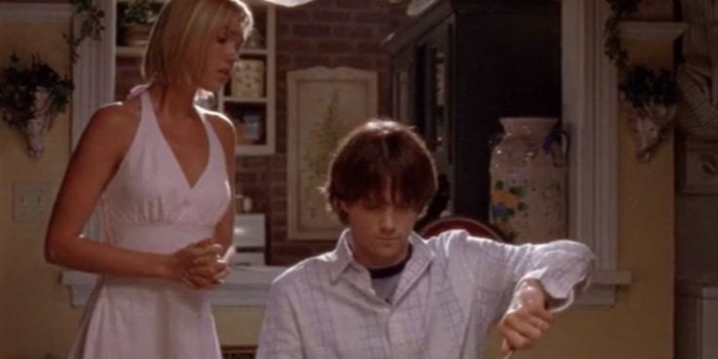 Lindsay olhando para Dean que está cortando comida em Gilmore Girls