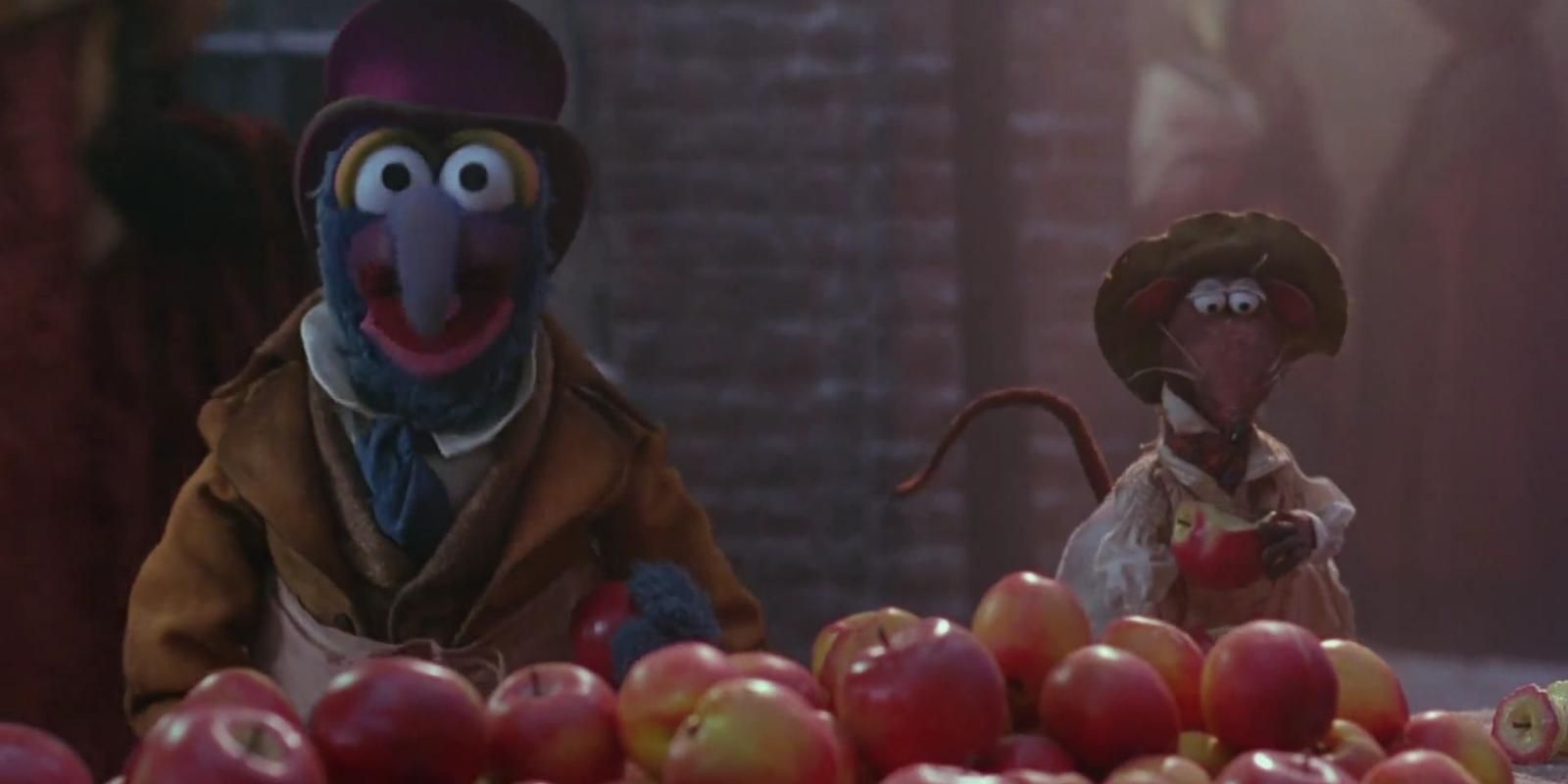 Gonzo the Great e Rizzo the Rat estão atrás de uma barraca vendendo maçãs em The Muppet Christmas Carol