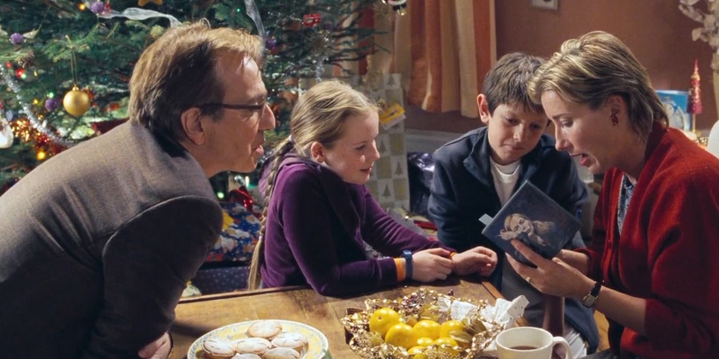 Harry, Karen and their kids sit around the Christmas tree and open their presents in Love Actually