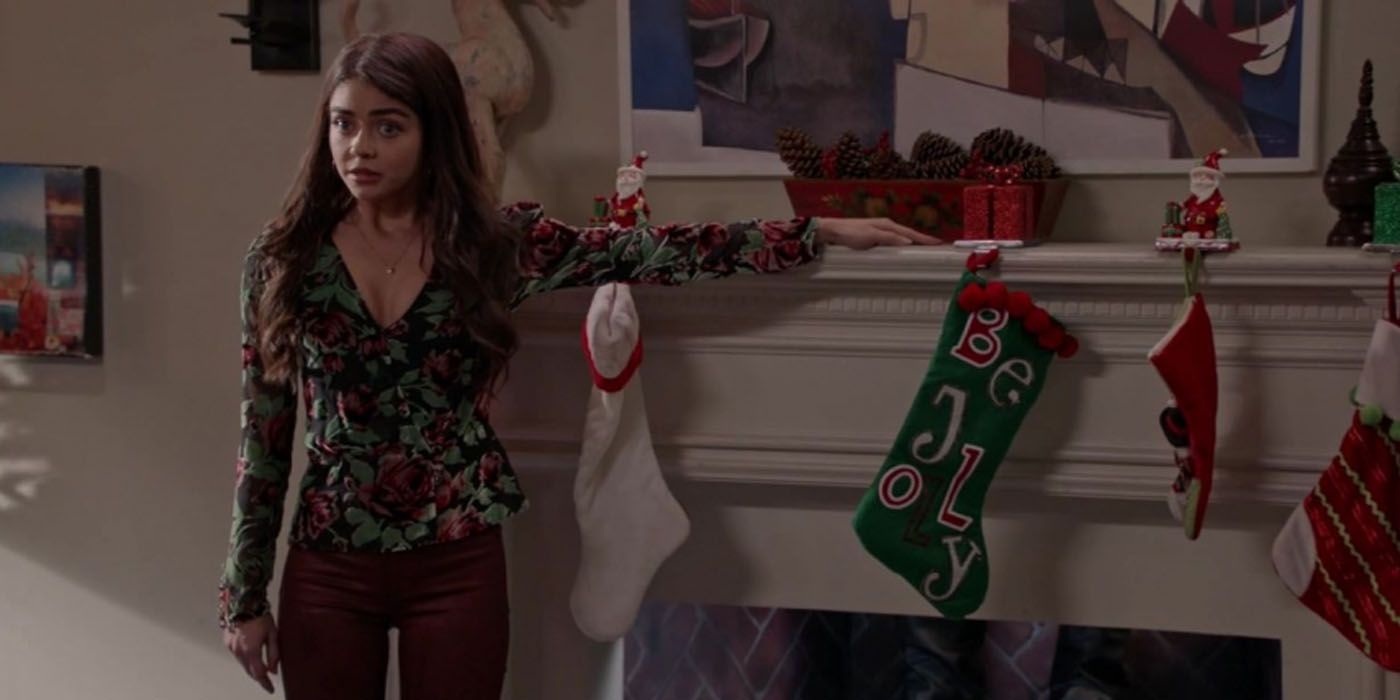 Haley parada frente a su chimenea en Navidad en Modern Family