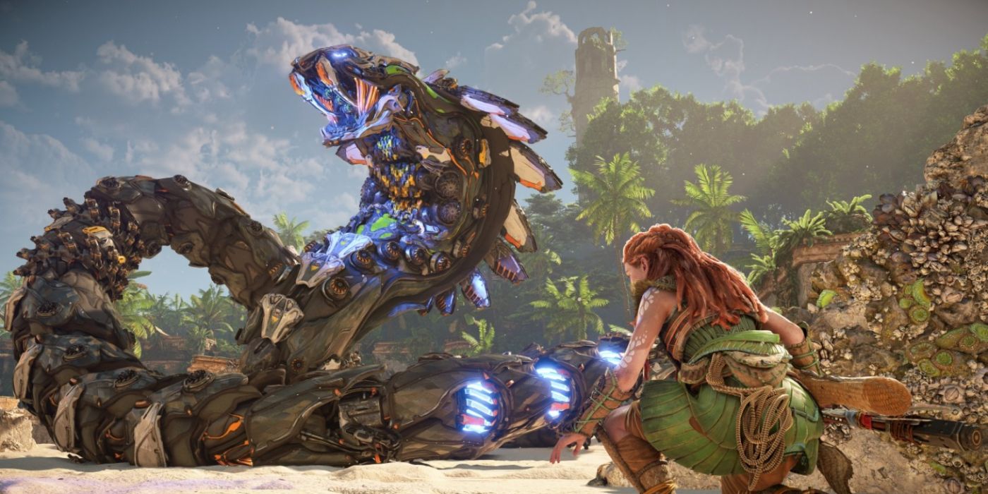 Horizon Forbidden West protagonist Aloy crouching behind cover near a Slitherfang, a giant snake-like machine.