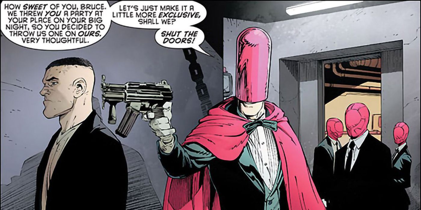 Joker pointing a gun at someone as Red Hood.