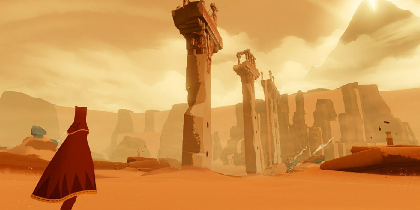 The player character walks towards ruins in a desert in Journey.