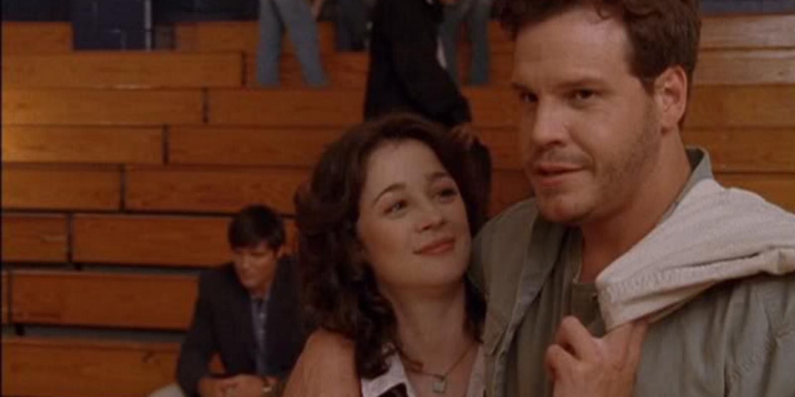 Keith Scott and Karen Roe embrace in the gym of Tree Hill High School in One Tree Hill