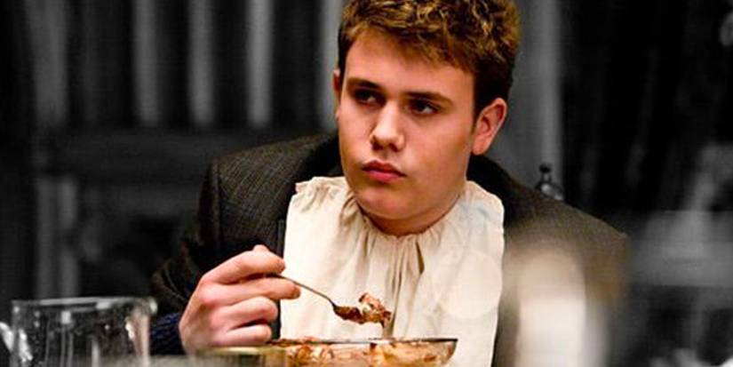 Marcus Belby (Robert Knox) eating at a table in Harry Potter