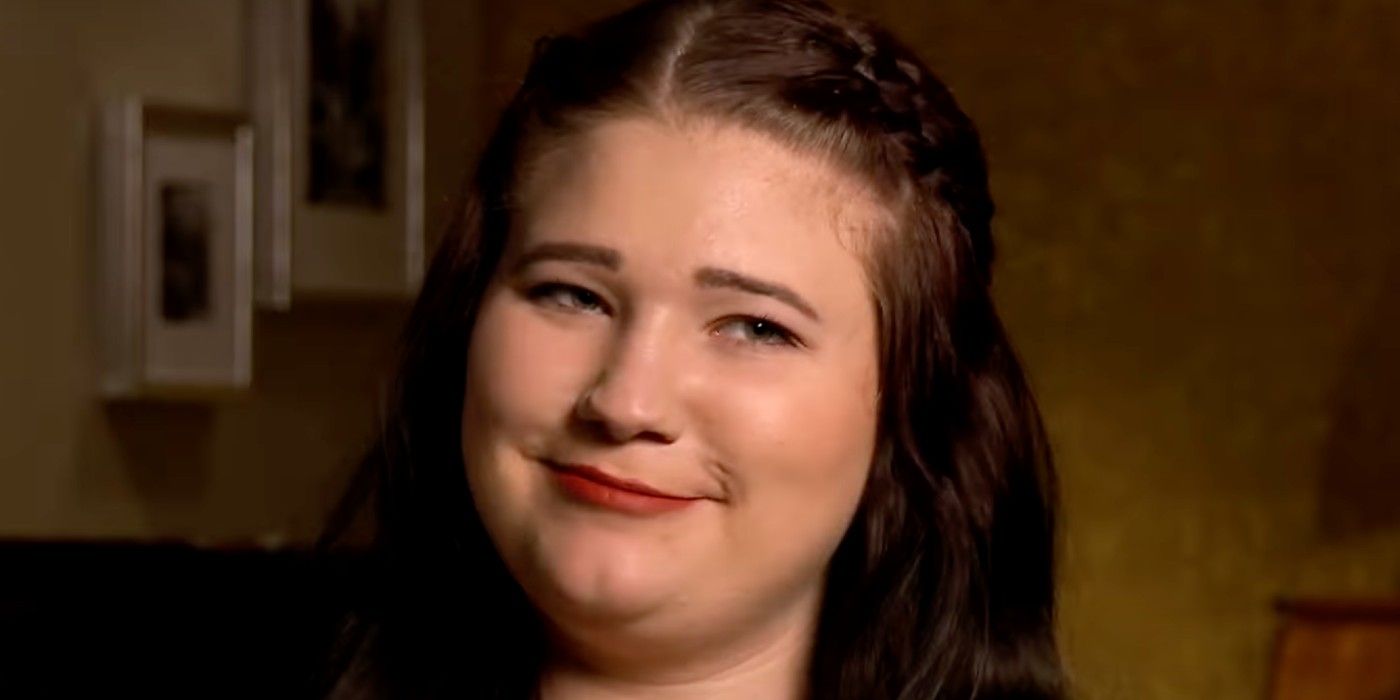 Sister Wives' Mykelti Brown smirking with dark background