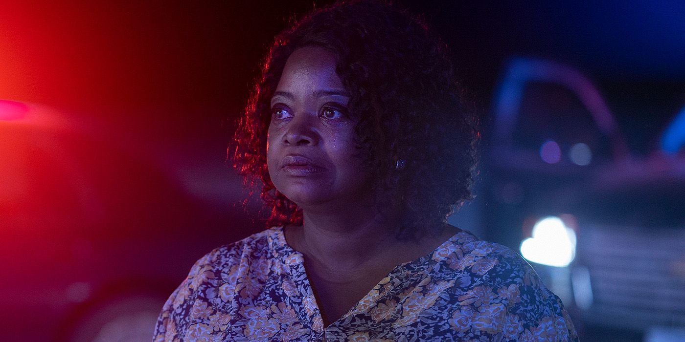 Octavia Spencer standing in front of police vehicles with flashing lights in Encounter.