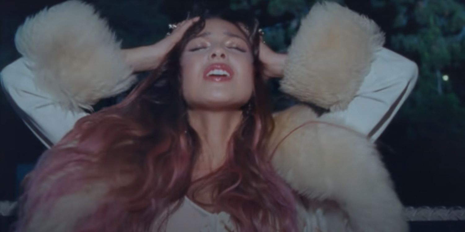 Olivia Rodrigo puts her hands to her head in the music video for Traitor