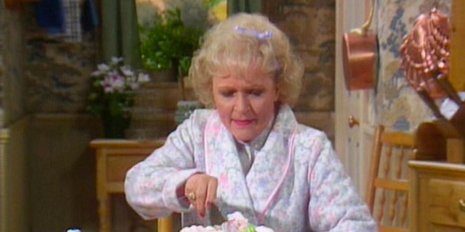Rose cuts her cake in her old kitchen while talking to Charlie after his passing on The Golden Girls
