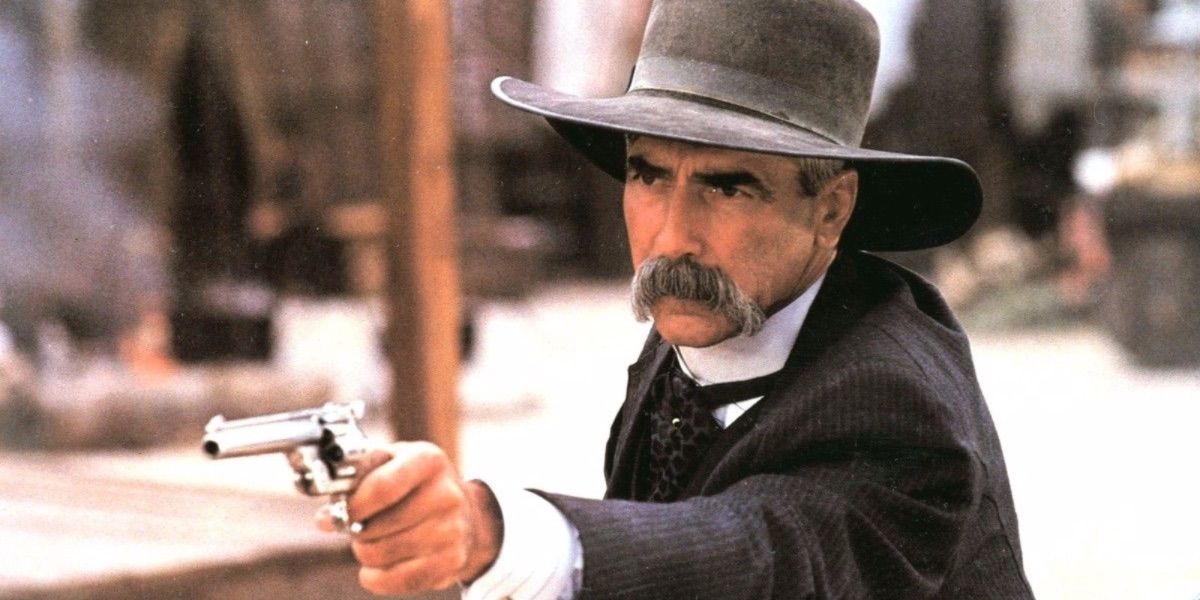 Sam Elliott point a pistol offscreen in Tombstone