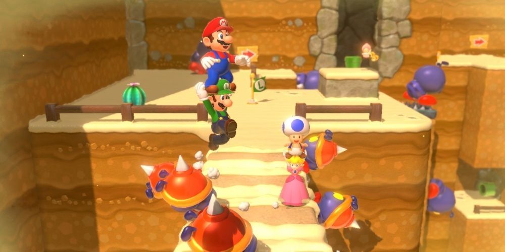 Mario stands on Luigi to fight off bad guys in Super Mario 3D World