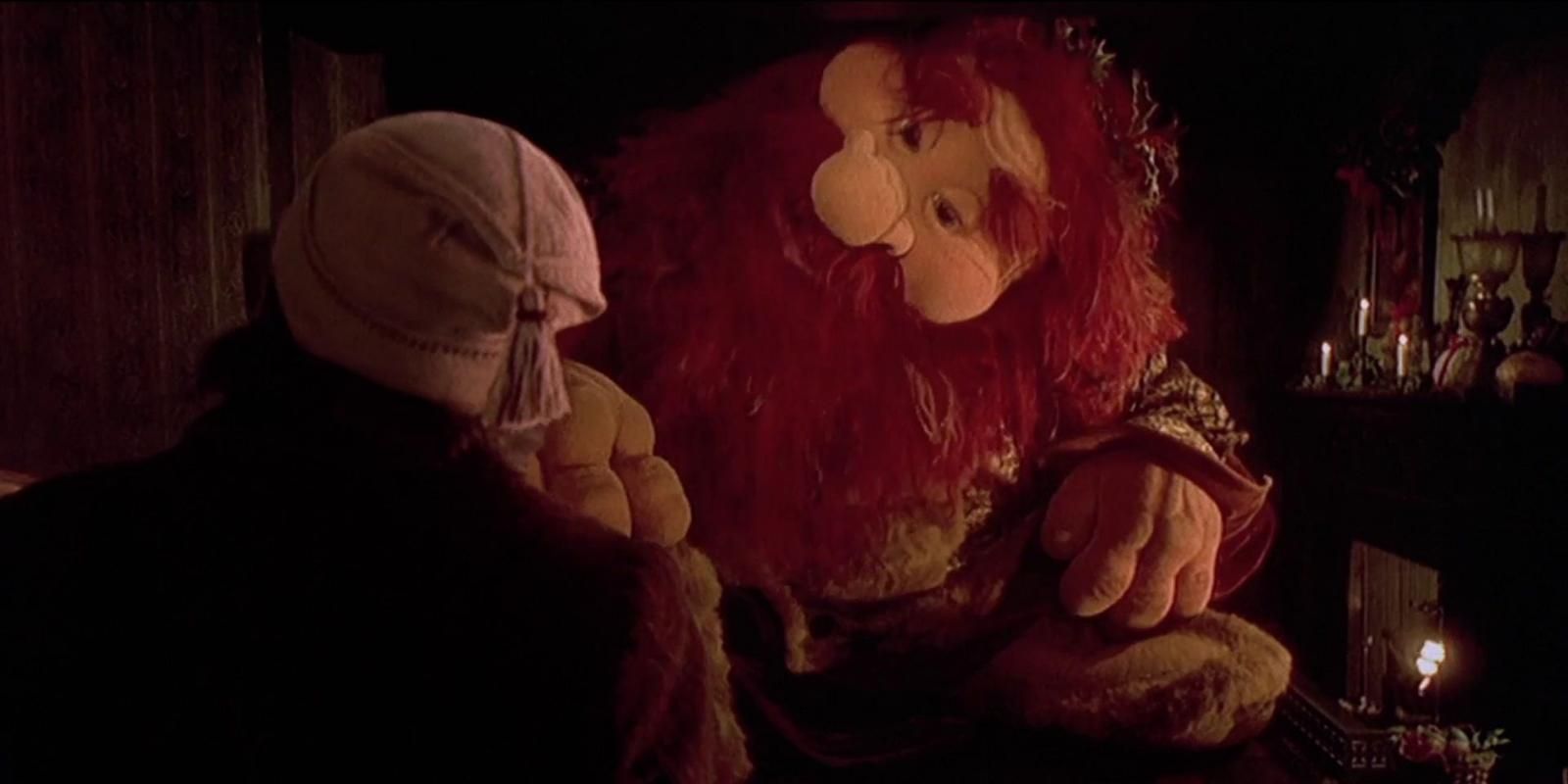 The Ghost of Christmas Present smiles at Ebenezer Scrooge in The Muppet Christmas Carol