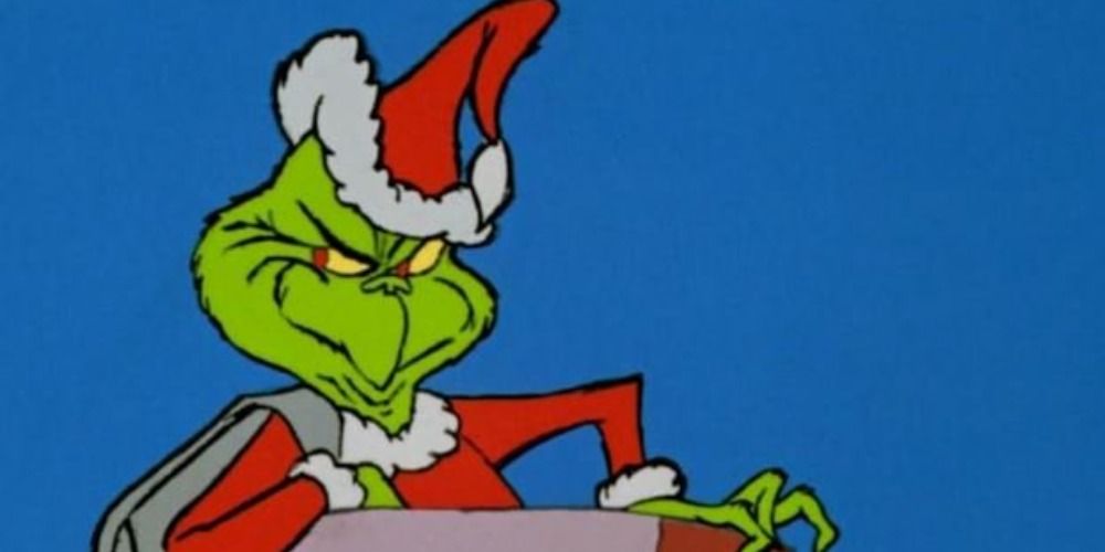 The Grinch leaning on his elbow looking mischievious in the original movie