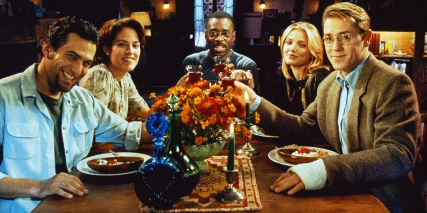 A group of people toasting at the dinner table in The Last Supper