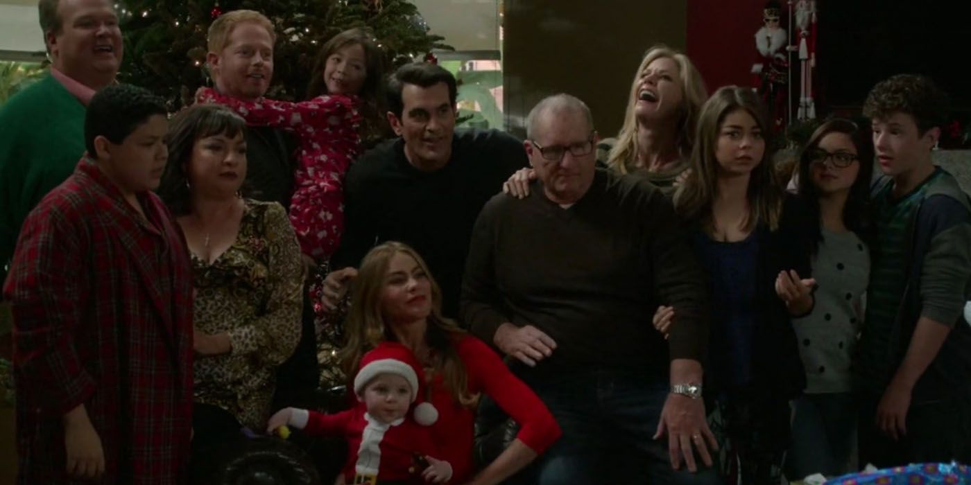 Toda la familia sonriendo alrededor del piano en el episodio navideño de Modern Family 