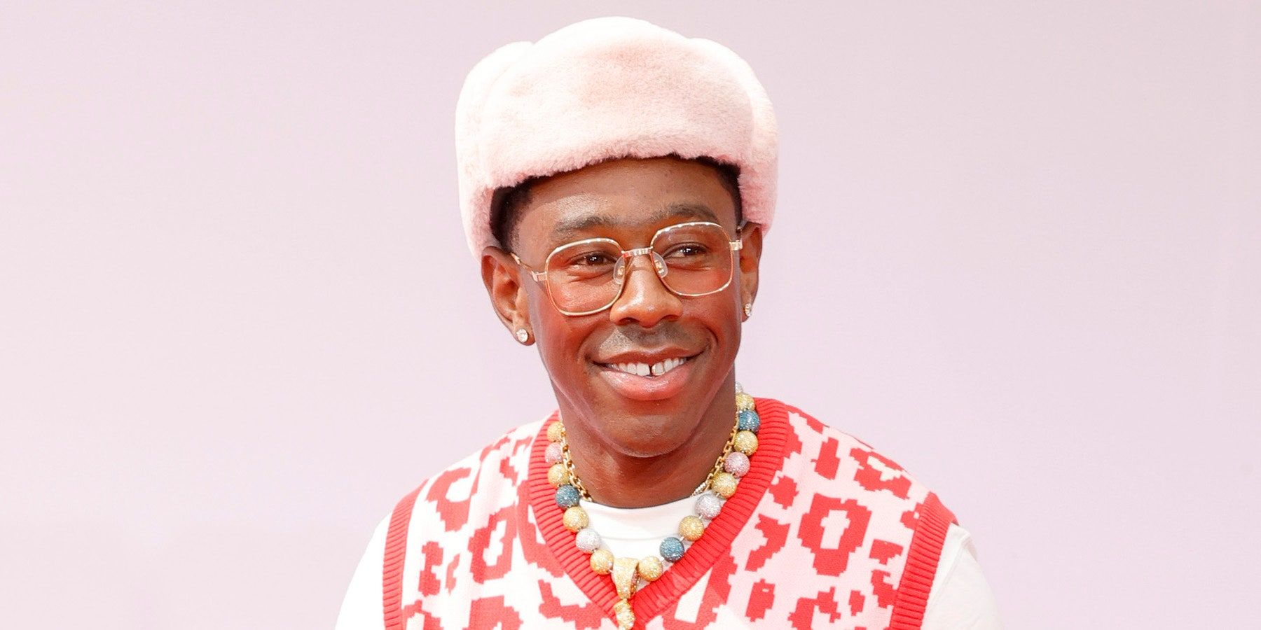 Image of Tyler the Creator against a pink background.