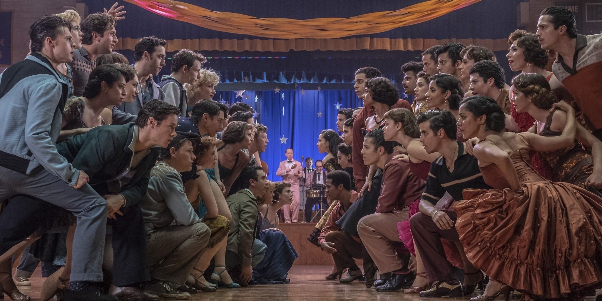 The characters glare at each other on the dance floor in West Side Story