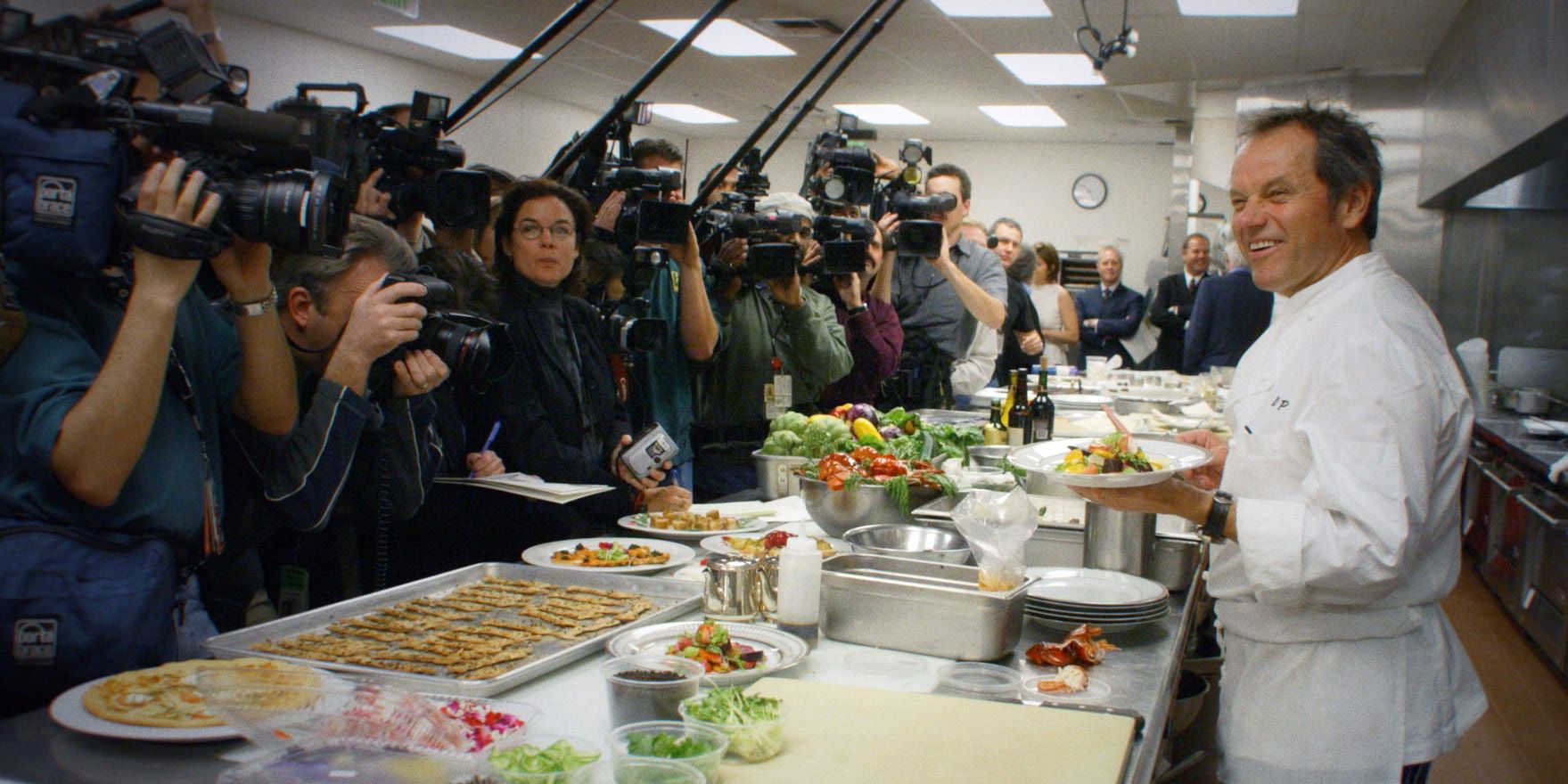 Wolfgang Puck stands in front of cameras in Wolfgang.