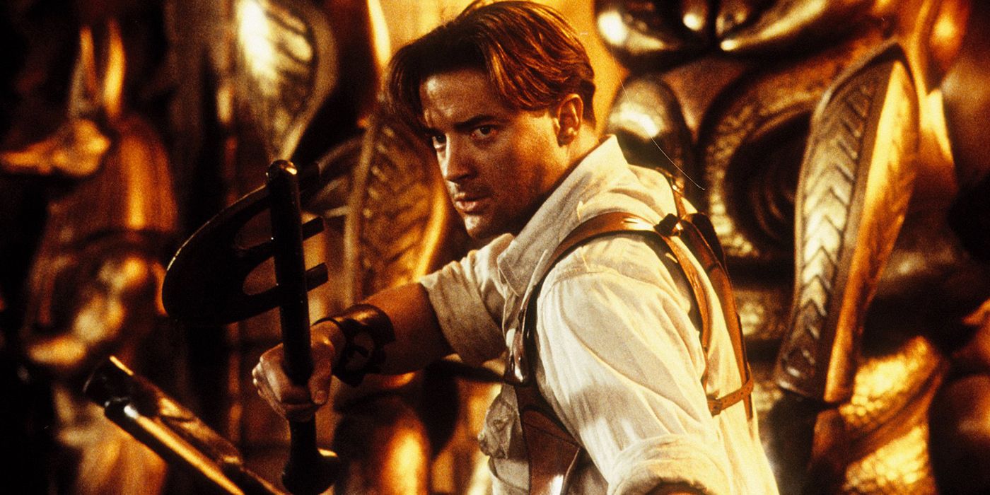 Brendan Fraser with a torch navigating a cave in a scene from The Mummy.