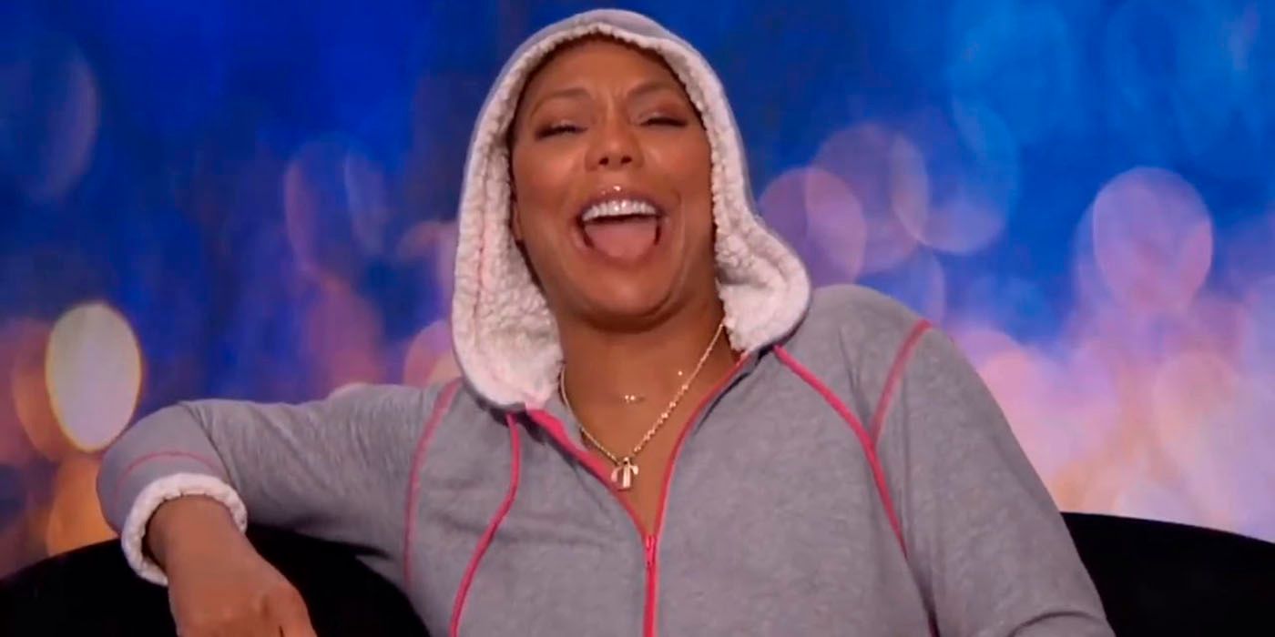 Tamar Braxton in the diary room on Celebrity Big Brother, her sweater hood over her head, laughing widely.