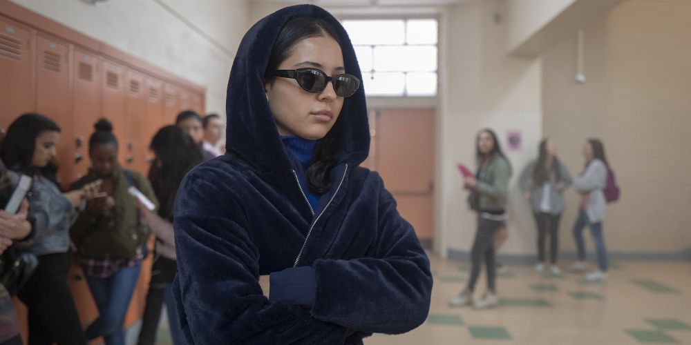 Maddy wears a hood and shades in the hall on Euphoria