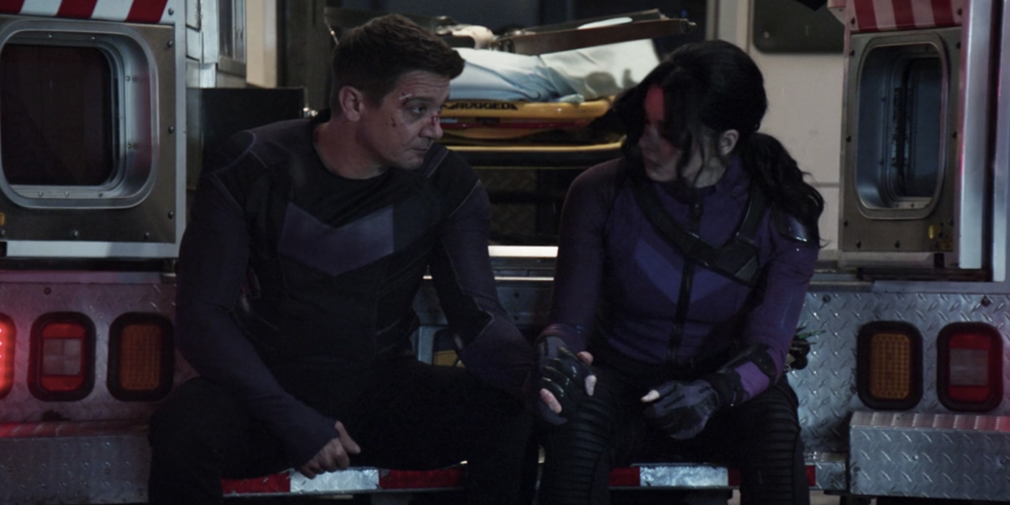 Clint and Kate sit in the back of an ambulance in Hawkeye