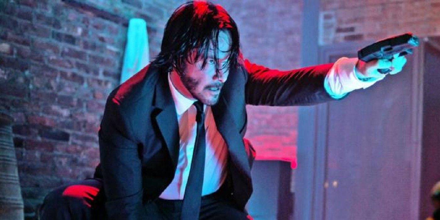 John Wick ajoelhado e apontando uma arma em John Wick