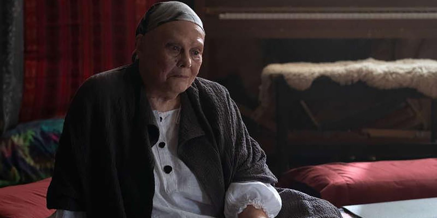 Lois Smith wearing a wrap around her head sitting on the ground in a scene from Ray Donovan.