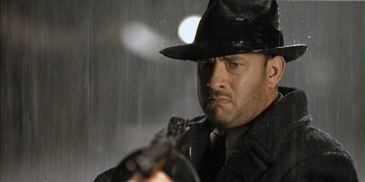 Tom Hanks holding gun in the rain in Road to Perdition