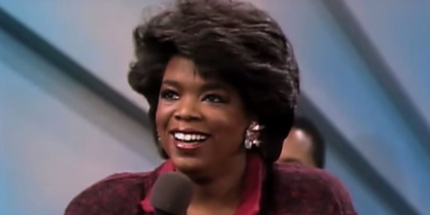 A close up of Oprah Winfrey with short hair smiling on her talk show in the '90s.