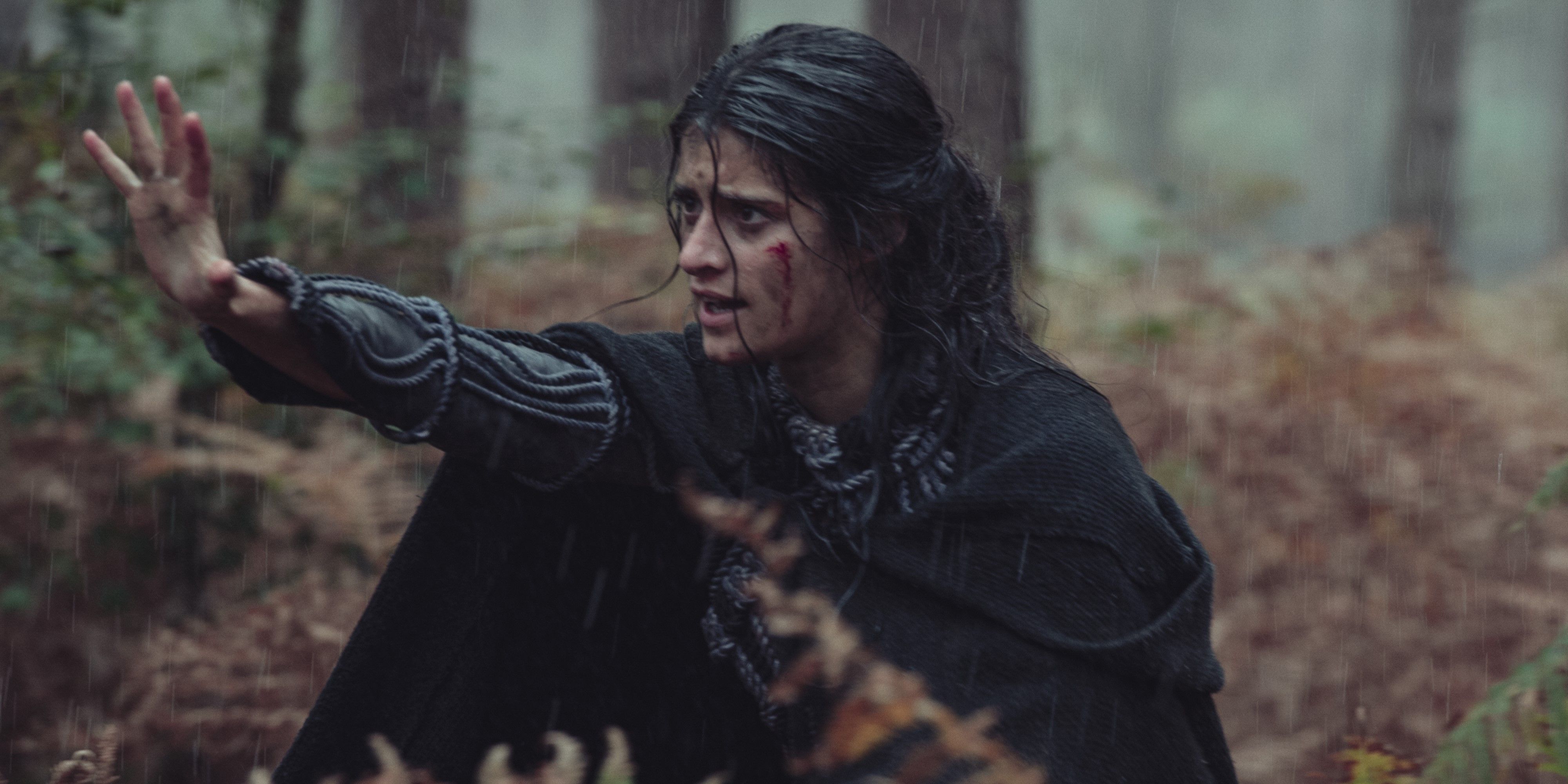 Yennefer defending herself in a rainy forest in The Witcher