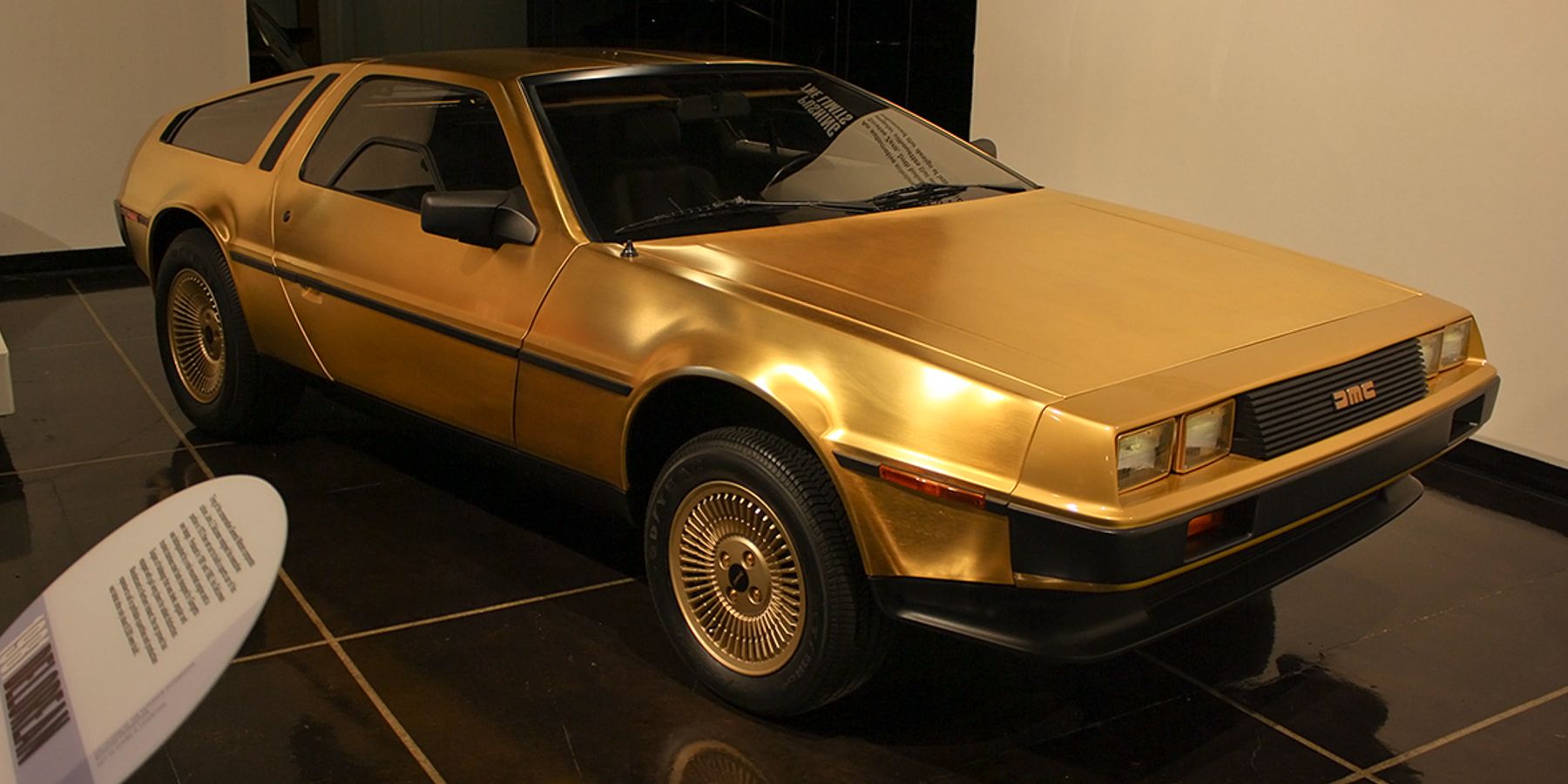 A golden DeLorean on display at a museum