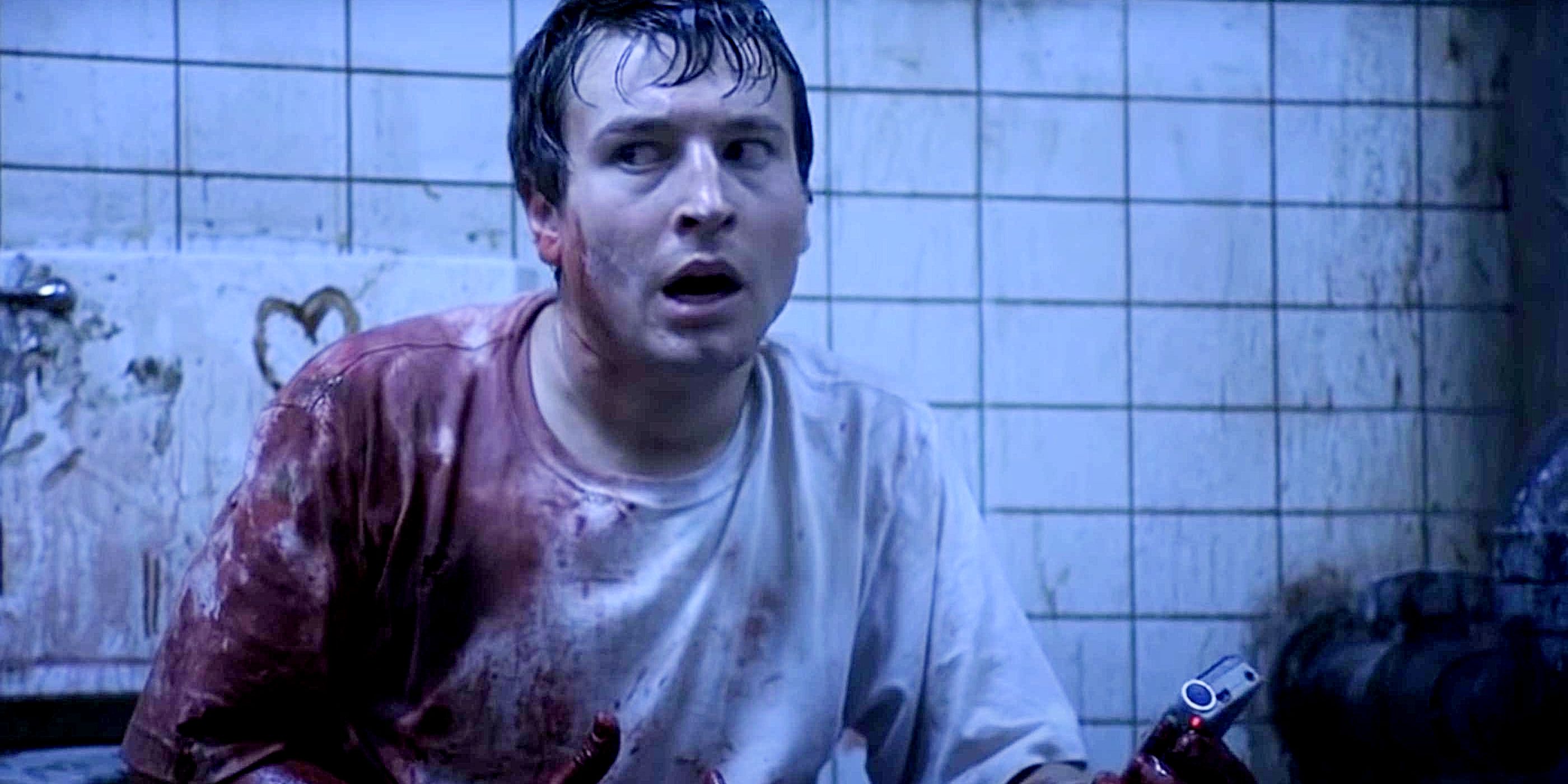 Adam looking shocked and covered in blood in Saw