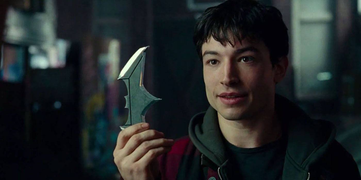 Barry Allen holding a batarang in the DCEU.