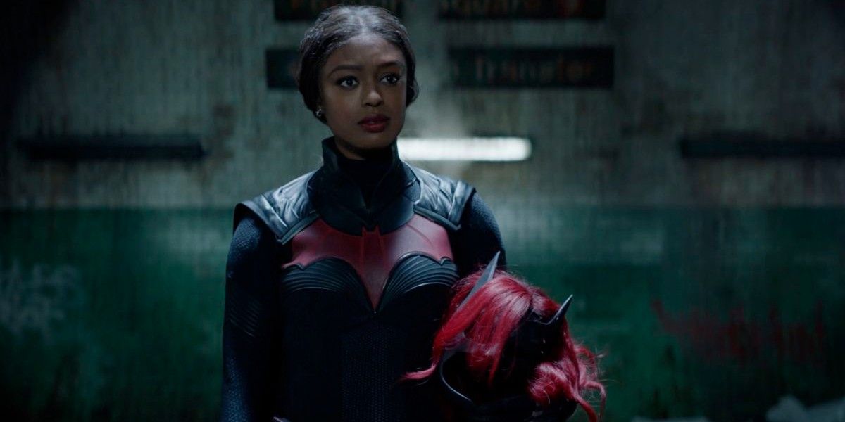 Batwoman played by Javicia Leslie holds her mask and wig in her hands