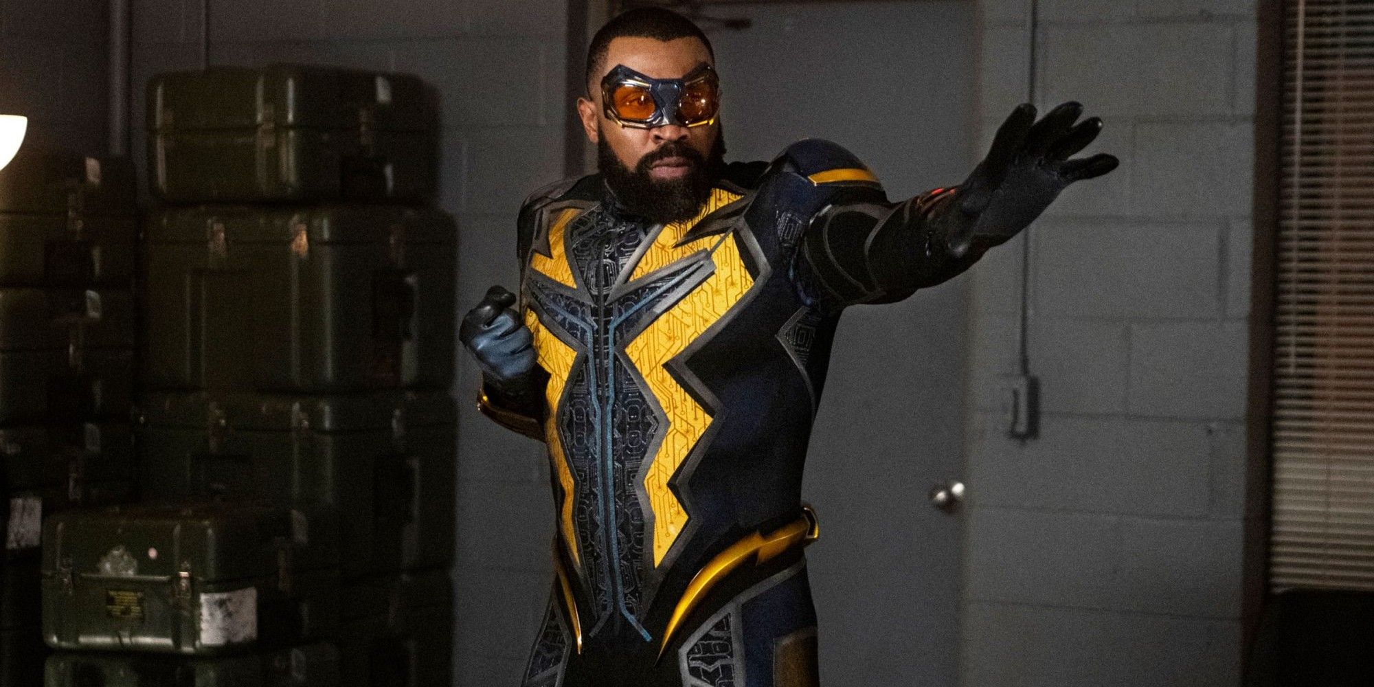 Black Lightning stands with his hands ready to electrocute