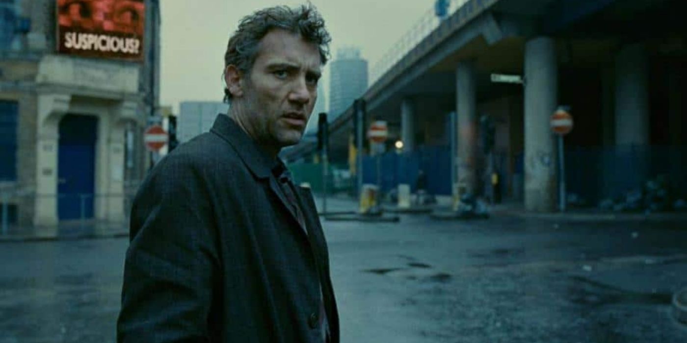 Theo standing and looking at something offscreen in Children Of Men