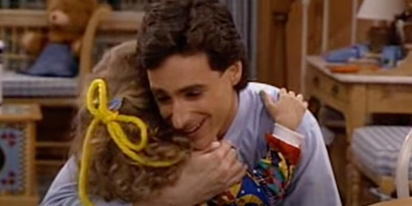 Danny Tanner abraça Stephanie Tanner na cozinha em Full House