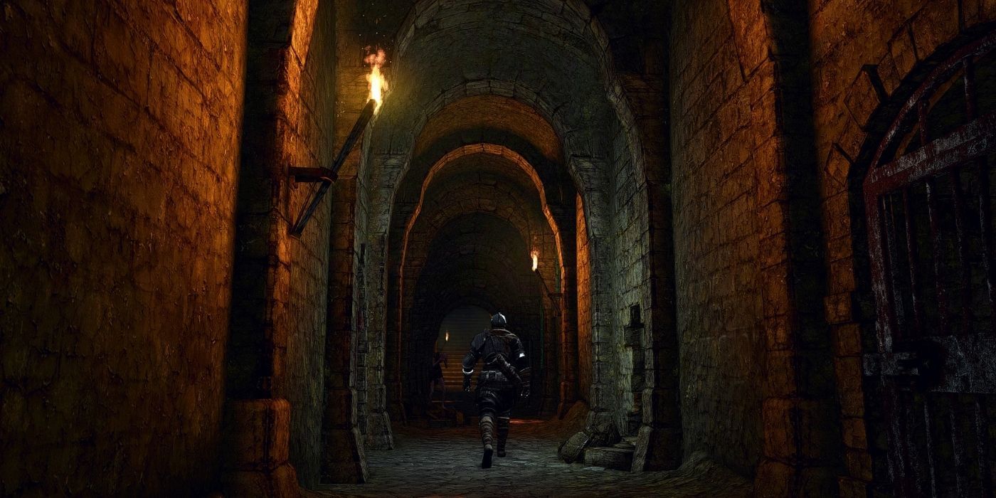 A character walking down a dark corridor in Dark Souls