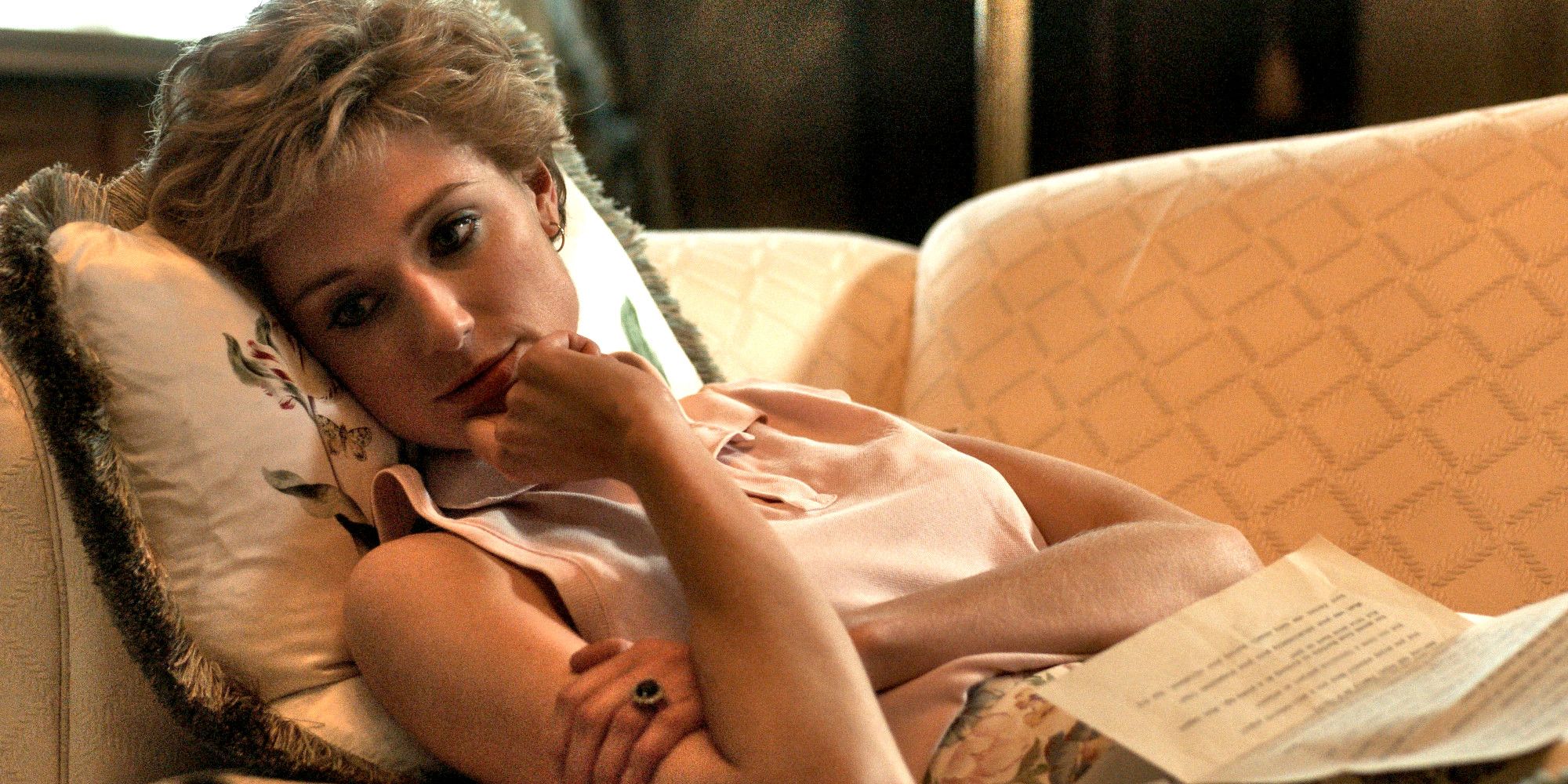 Princess Diana lying on a couch looking pensive in The Crown.