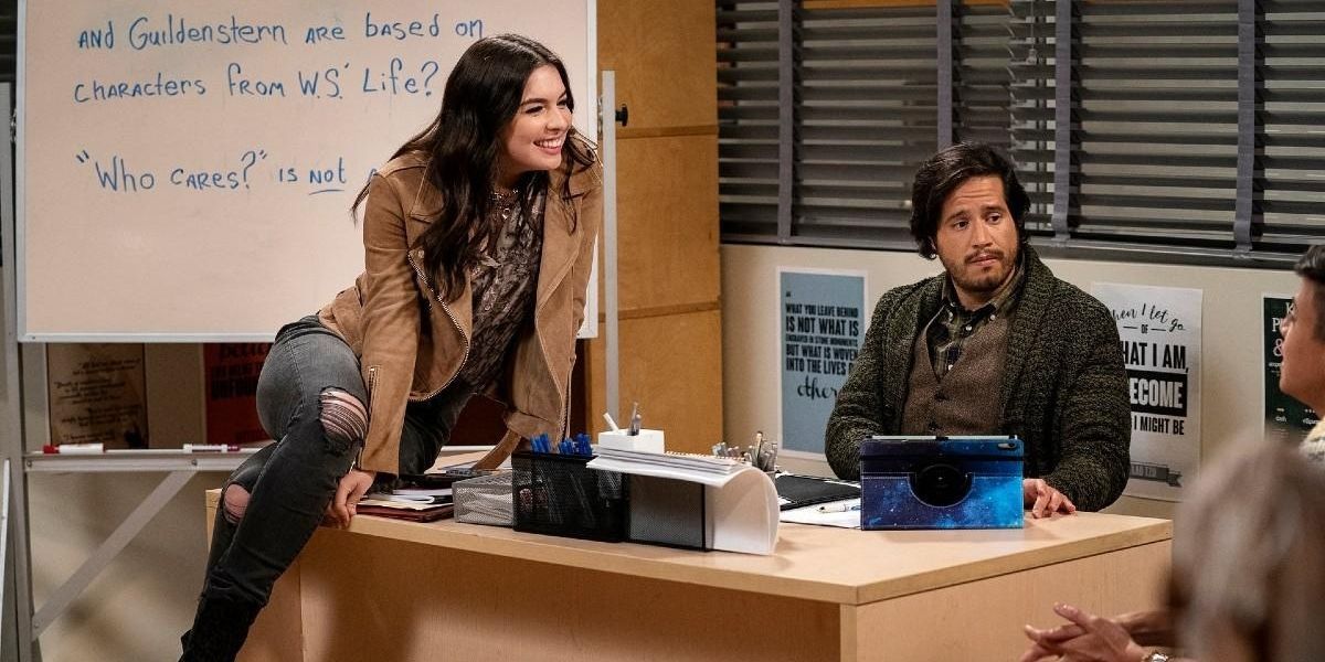 Alicia sitting on another teacher's desk in Head Of The Class