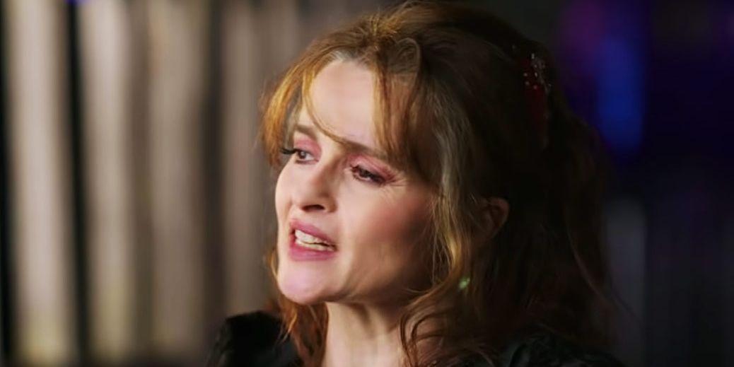 Helena Bonham Carter is captured mid-conversation in front of a blurry backdrop.