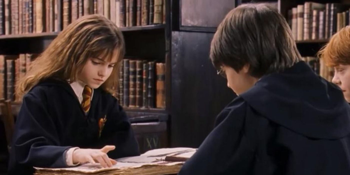 Hermione studying with Harry and Ron in the library in Harry Potter